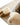 Cozy chestnut sheepskin slippers with plush wool lining placed on a textured woven rug beside a soft sheepskin throw, showcasing the warmth, comfort, and natural luxury of genuine sheepskin products from kiwi sheepskins