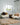 Modern living room with two black metal chairs draped over a fluffy long  sheepskin rugs, fluffy long sheepskin wool cushions, and an extra large sheepskin rug on the floor, all available in kiwi sheepskins