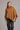 A model wearing a honeycomb poncho with a diagonal detail and asymmetric neckline, made of possum merino, and mulberry silk fabrics from kiwi sheepskins