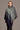 A woman wearing a grey, blue green, and dark violet ombre pattern poncho from kiwi sheepskins