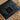 Kiwi Sheepskins luxury gift box wrapped in elegant black japanese tissue paper with a gold McDonald New Zealand label, presented in a brown box on a soft sheepskin wool