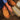 Person wearing chestnut Sheepskin Slippers for men and reading an open book on a dark brown Sheepskin rugs #color_chestnut