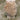 Person holding a fluffy sand color Sheepskin rugs with long sheepskin fur in a natural setting with grass and sand #color_sand