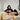 Woman relaxing with a cup of tea on a sofa covered in soft, natural sheepskin rugs and cushions.