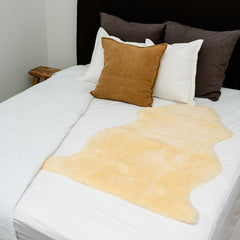 Bowron FleeceEase medical sheepskin wool mattress topper on a bed for comfort and pressure relief.