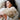 A sleeping woman wearing long sleeve stripes hugging a natural sheepskin hot water bottle cover in beige from kiwi sheepskins, comfortably laying her head on an ivory white kiwi sheepskin long wool cushion