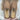 Pair of brown Sheepskin Slippers with fluffy sheepskin fur interior held by a person wearing a white sweater #color_sand