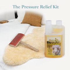Pressure relief kit with sheepskin rug, brush, and bottle labeled 'Woolskin' cleaner on a bed