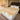 A large Medical sheepskin Wool mattress topper placed on a neat bed with white linen and two white pillows, designed to prevent pressure sores and discomfort from prolonged immobility from kiwi sheepskins
