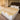 A large Medical sheepskin Wool mattress topper placed on a neat bed with white linen and two white pillows, designed to prevent pressure sores and discomfort from prolonged immobility from kiwi sheepskins